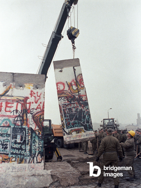 A piece of Berlin Wall is lifted in order to build another border crossing in 1989
