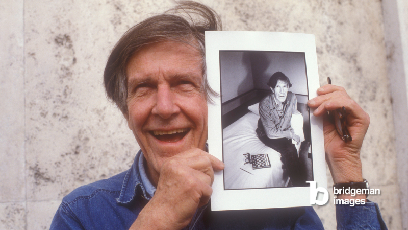 Music composer John Cage in Rome showing a picture of himself