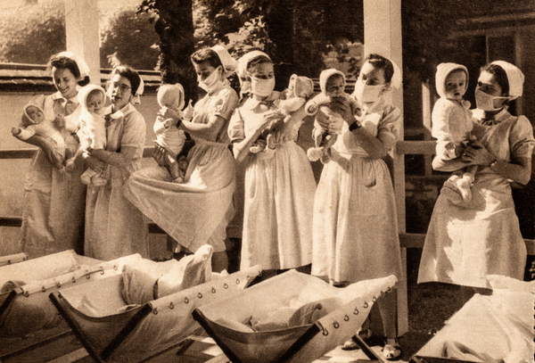 image of Masked Nurses Attend to Infants at Hospital Saint-Michel, Paris, Paris, France, c.1935 (postcard) / Private Collection / The Burns Archive and Museum of Historical Photography / Bridgeman Images