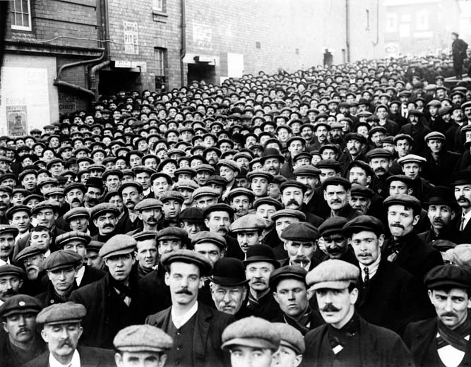 Miners waiting to go into the mass meeting at Empire Theatre, Tonypandy on the 9th November 1910 National Museum Wales