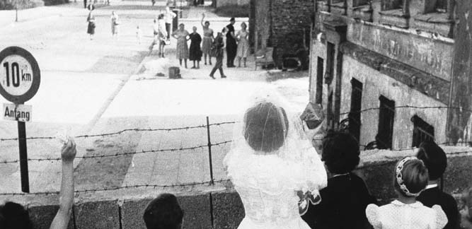 Newlyweds at the Berlin Wall waving to their relatives in East Berlin on 1st January, 1962 German Photographer / SZ Photo